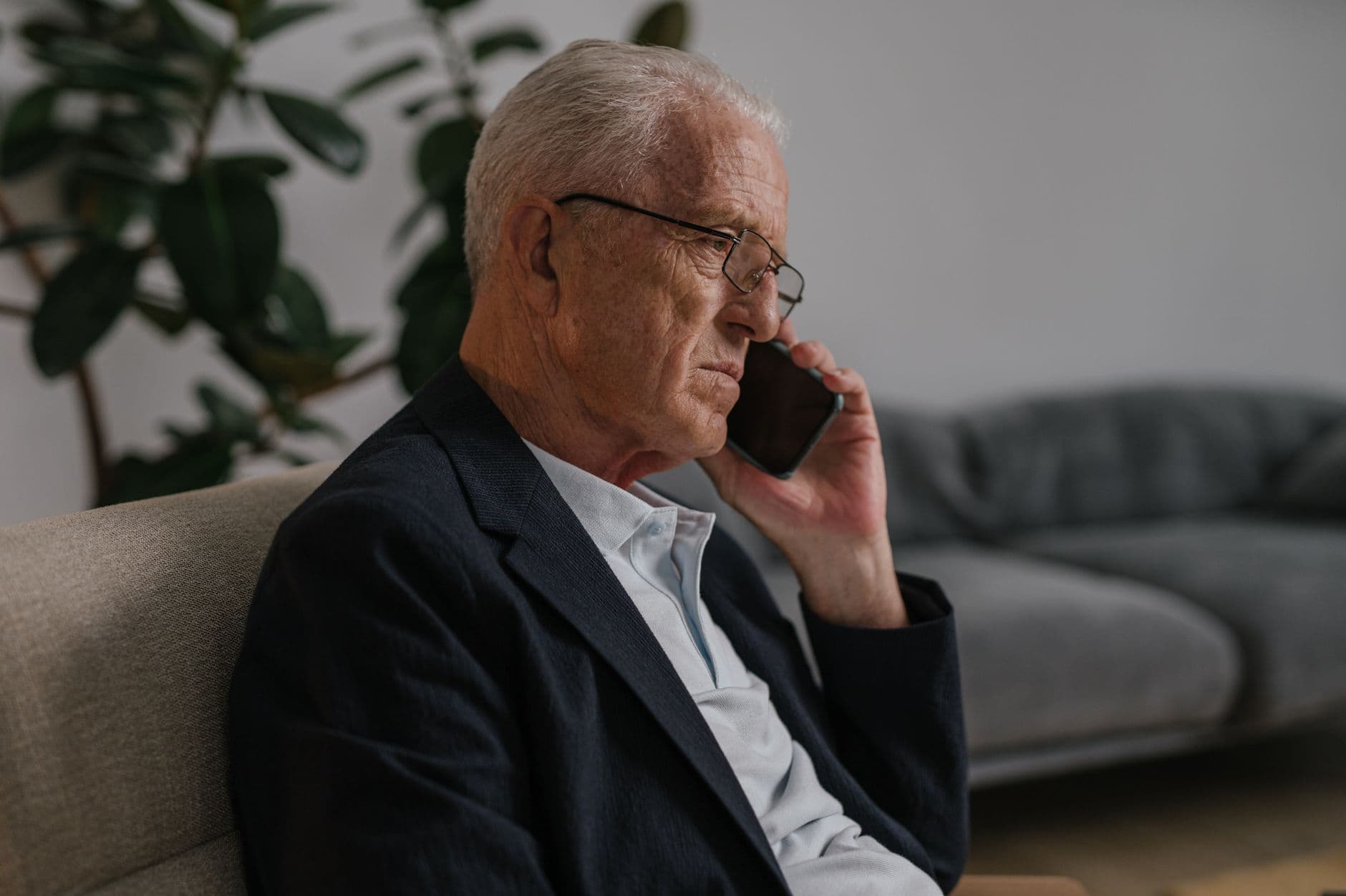 A man answering a ringing phone in his living room