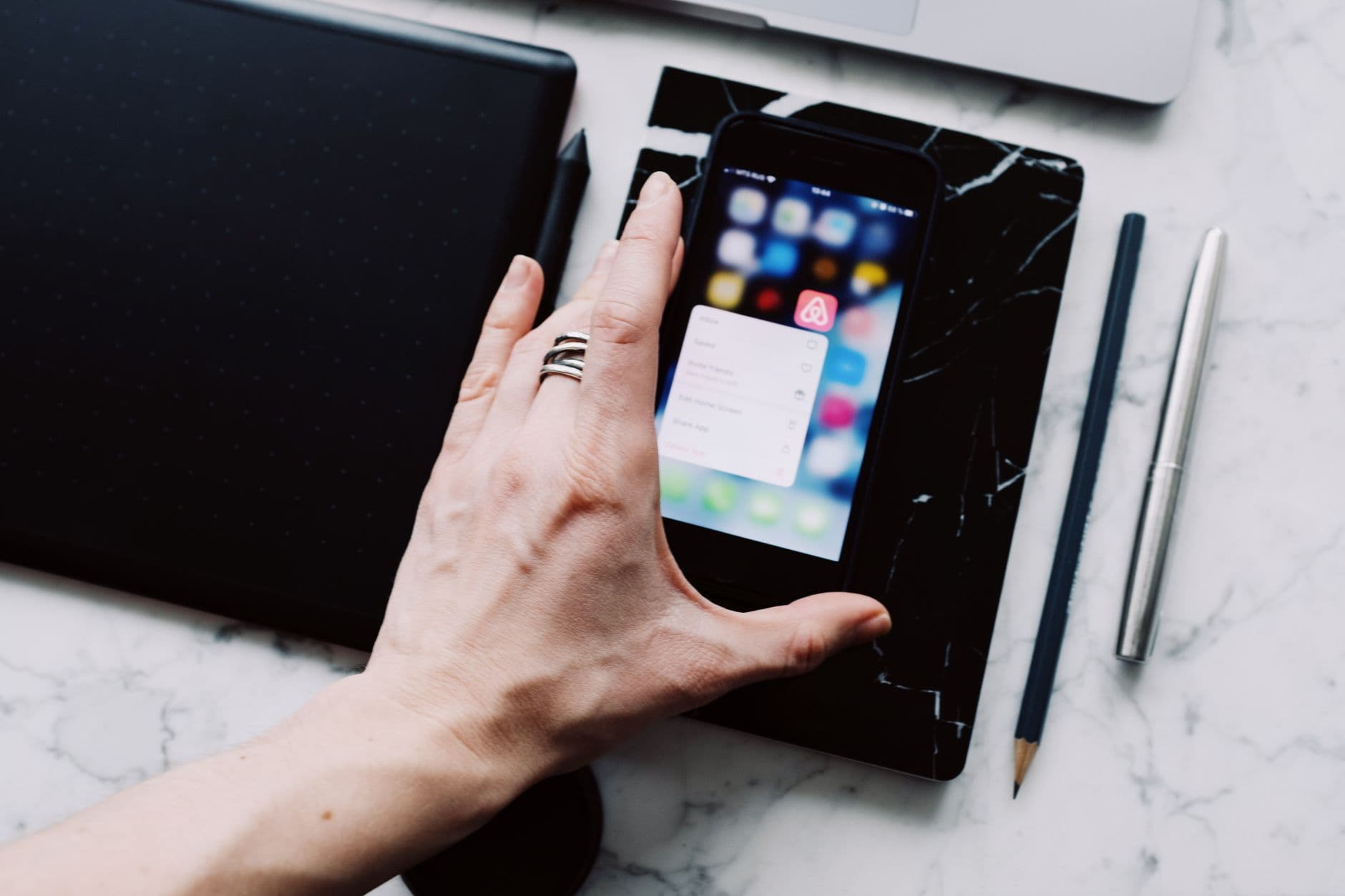 Several smartphones lying on a desk with different apps open