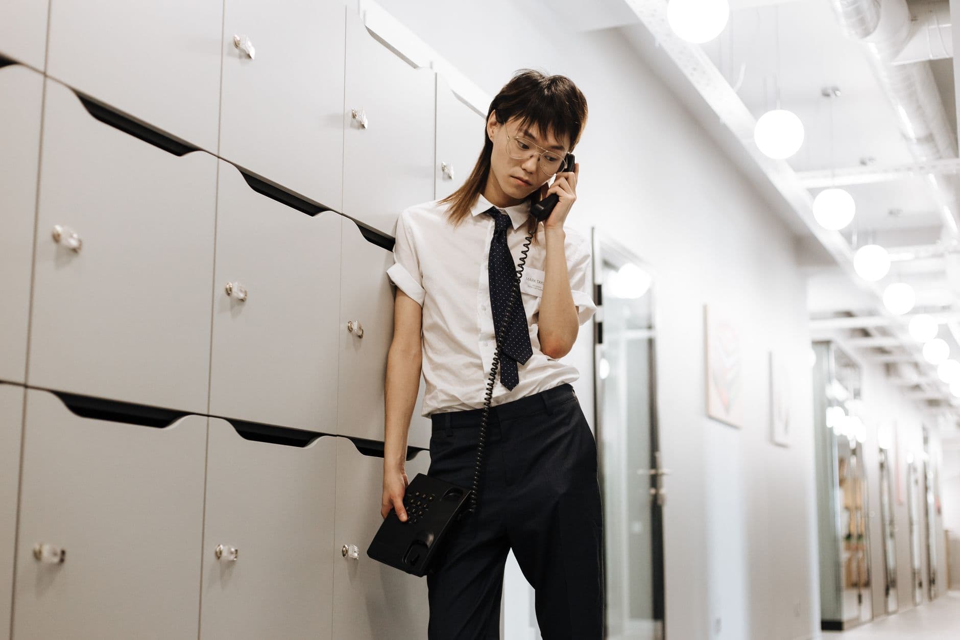 A woman answering a ringing phone in a hallway