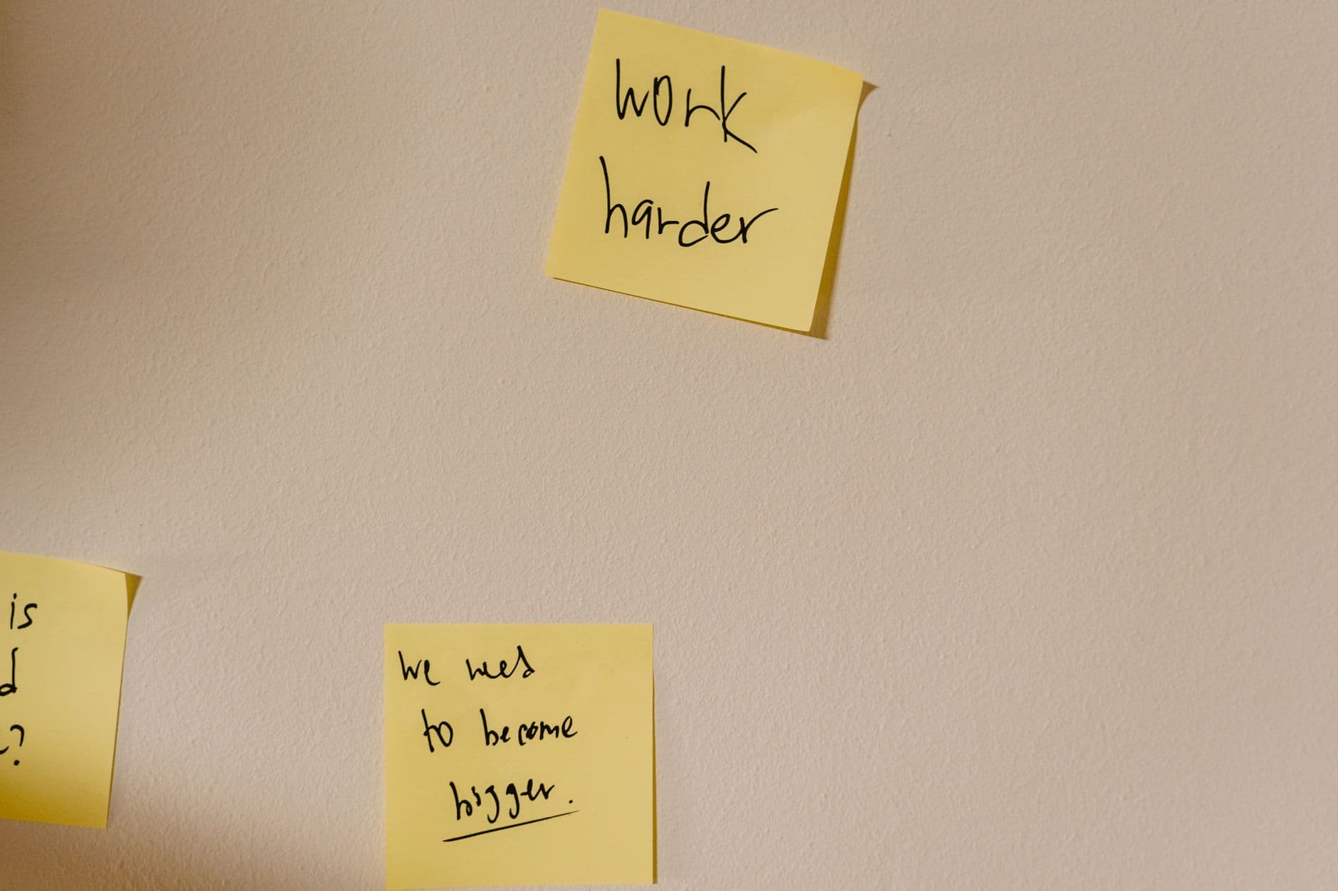 Handwritten sticky notes stuck up beside an open laptop