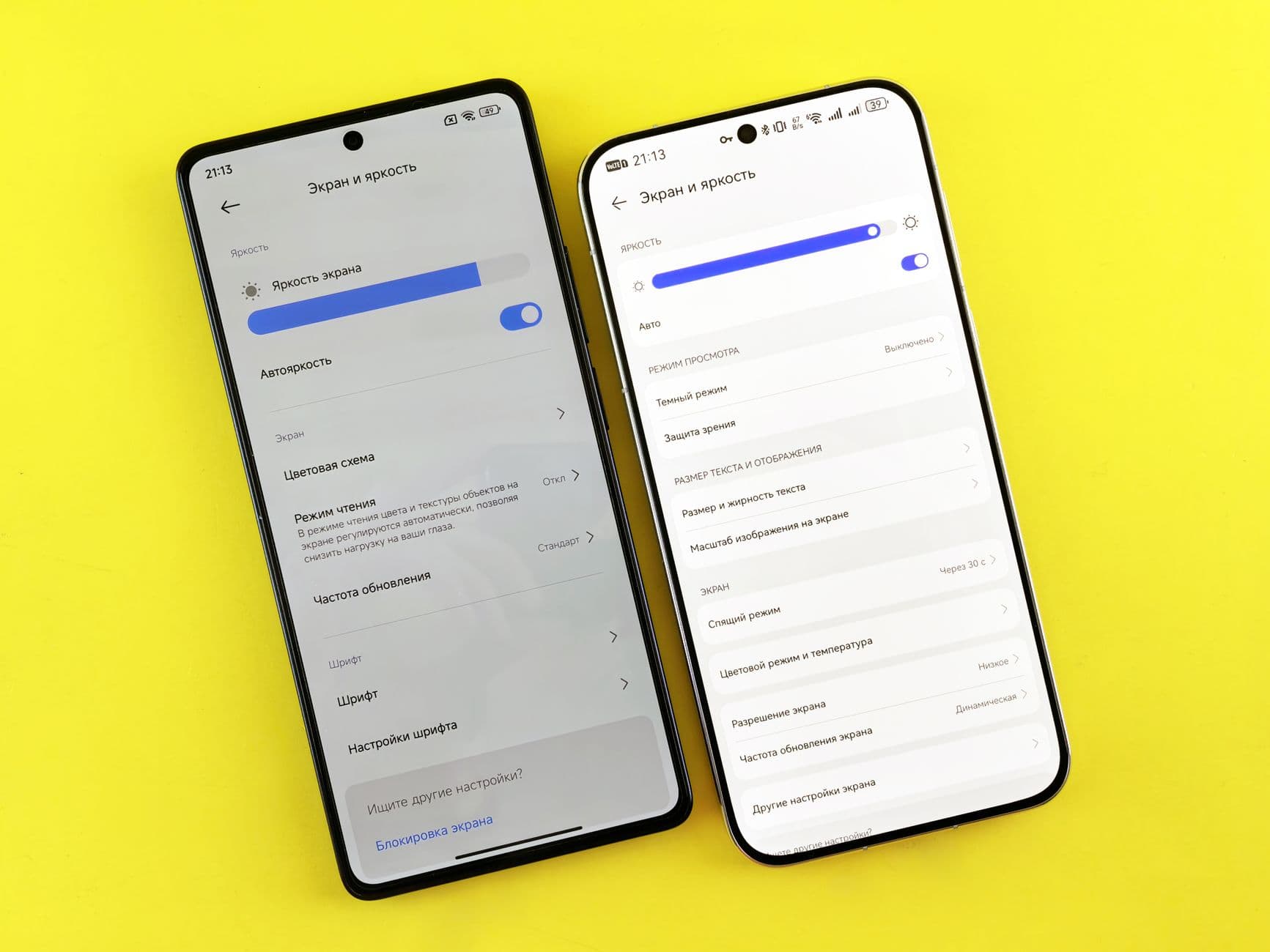 Two smartphones lying side by side on a wooden desk