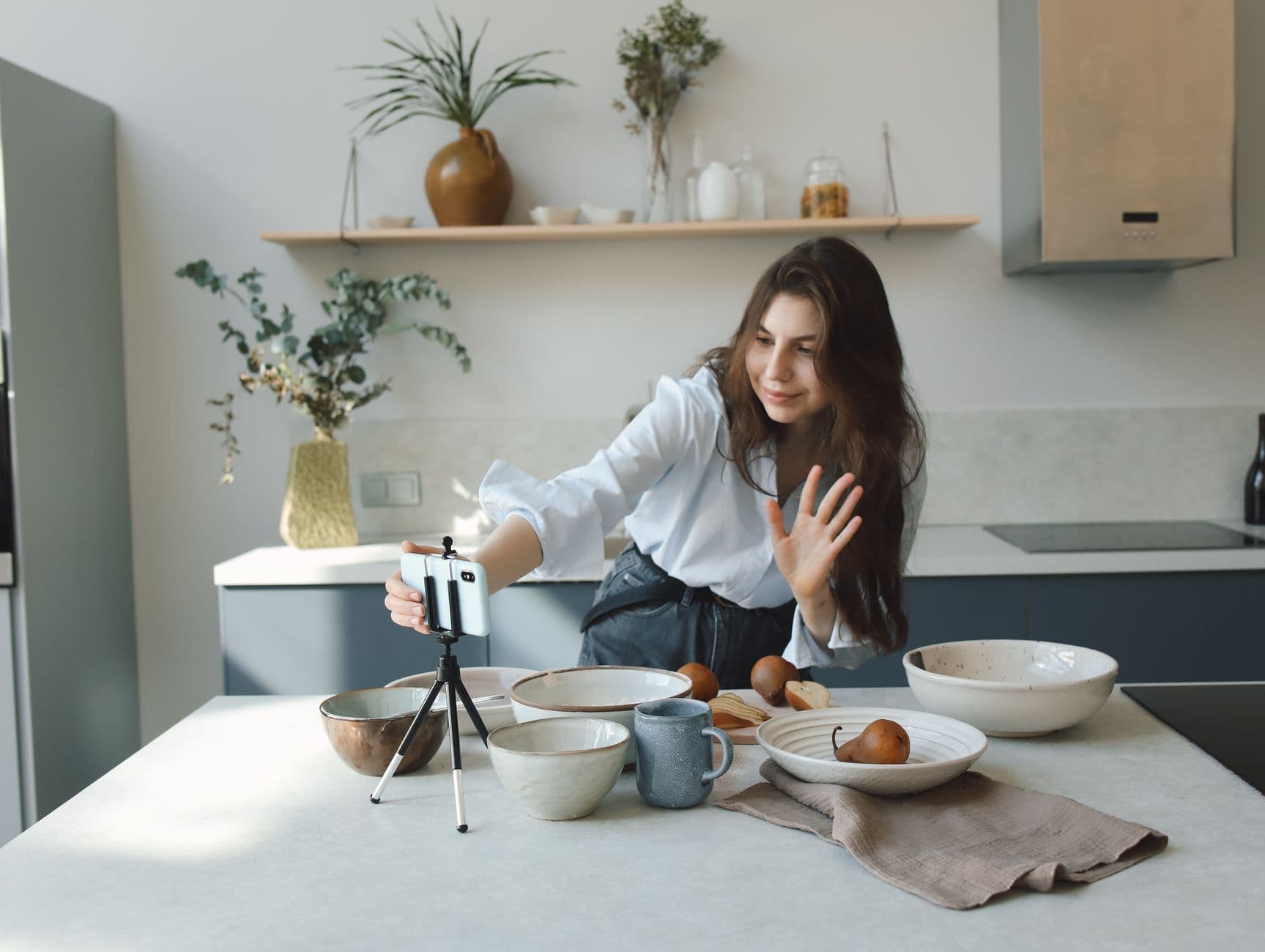 A phone ringing on a kitchen counter while someone cooks