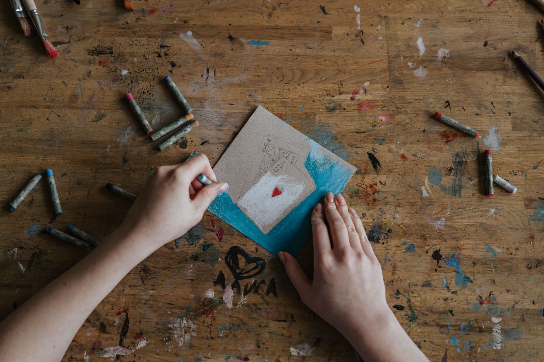 Hands writing a birthday card at a kitchen table