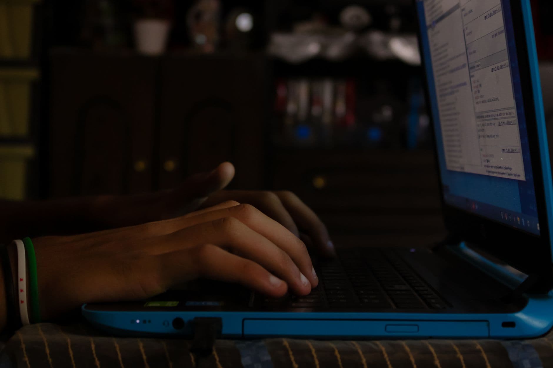 Someone typing at a laptop keyboard in a quiet room