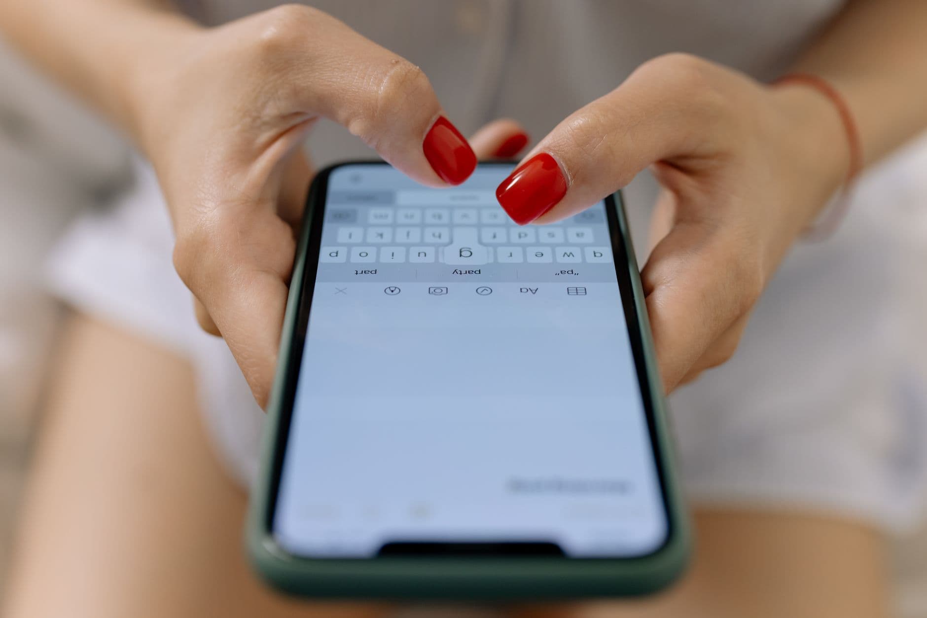 Hands typing a search into a smartphone in a kitchen