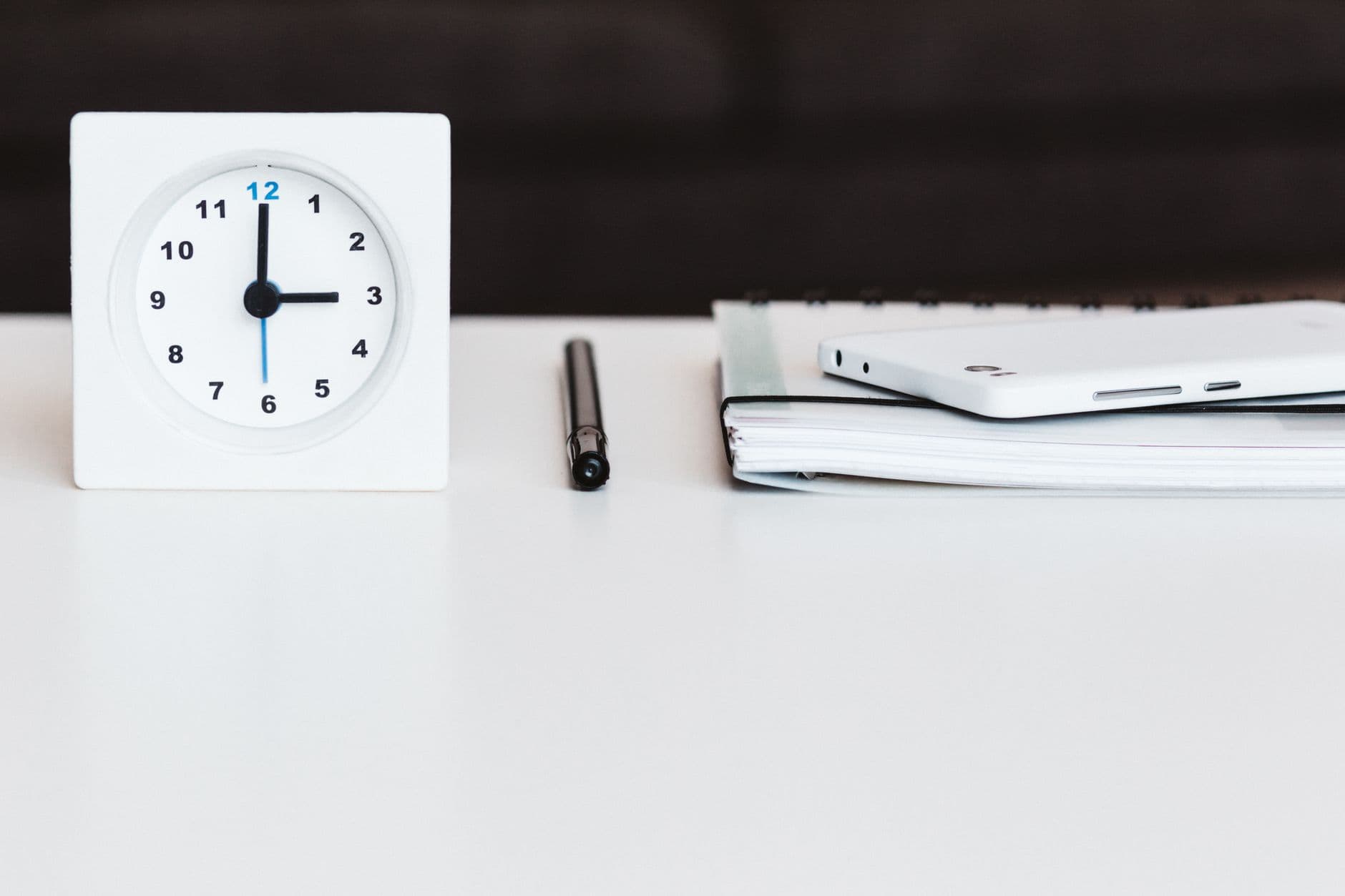 A phone and a notebook side by side on a desk
