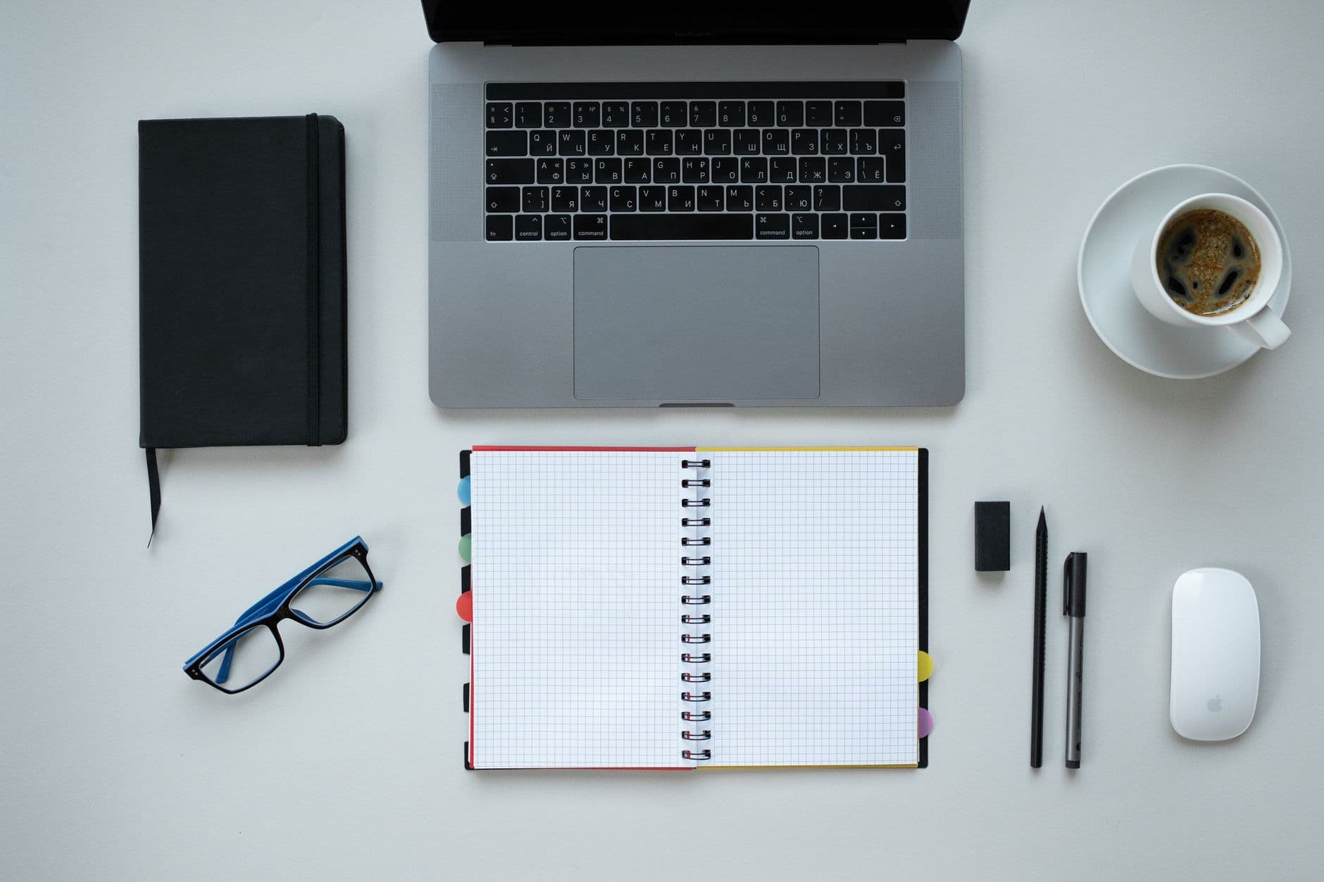 A notebook and laptop on a desk before a meeting