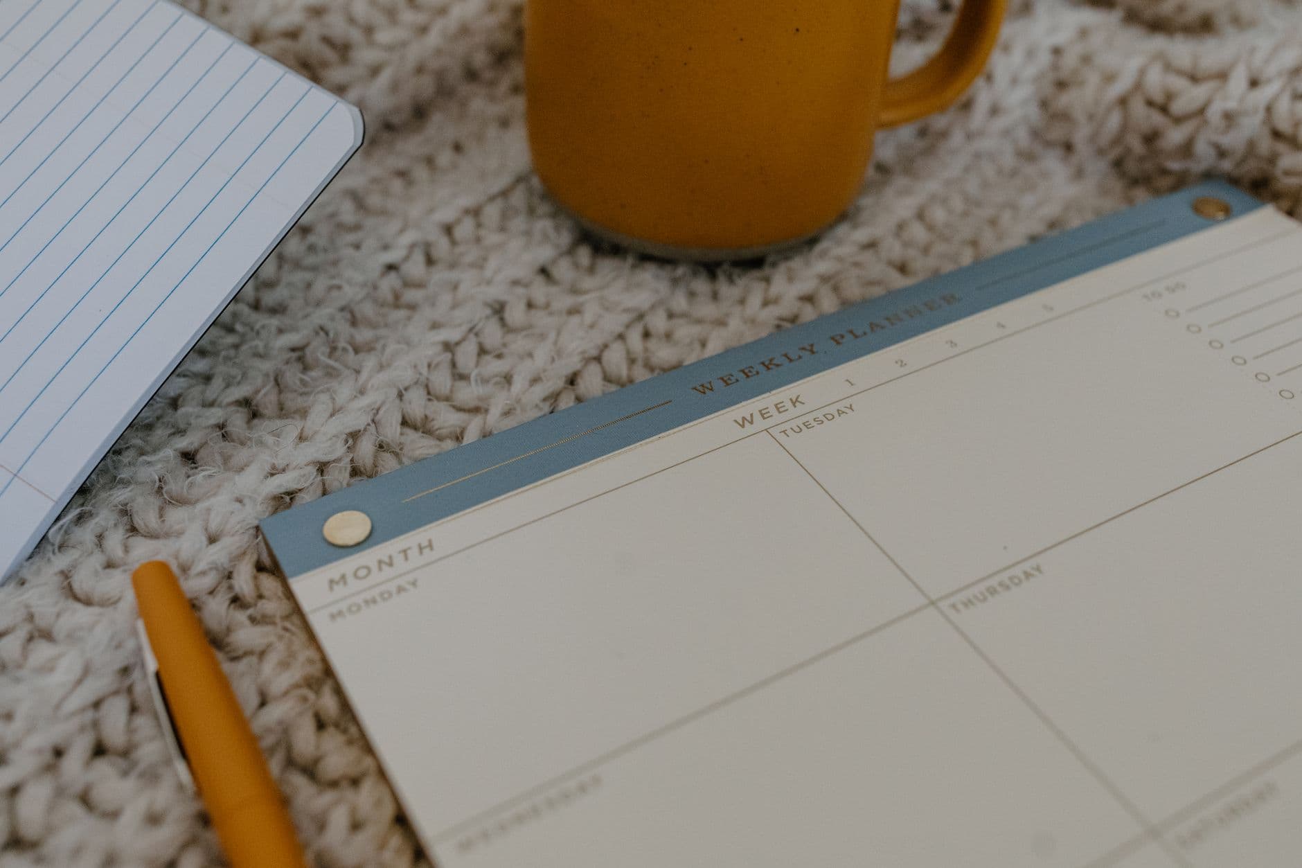A weekly planner notebook with checkmarks beside each day