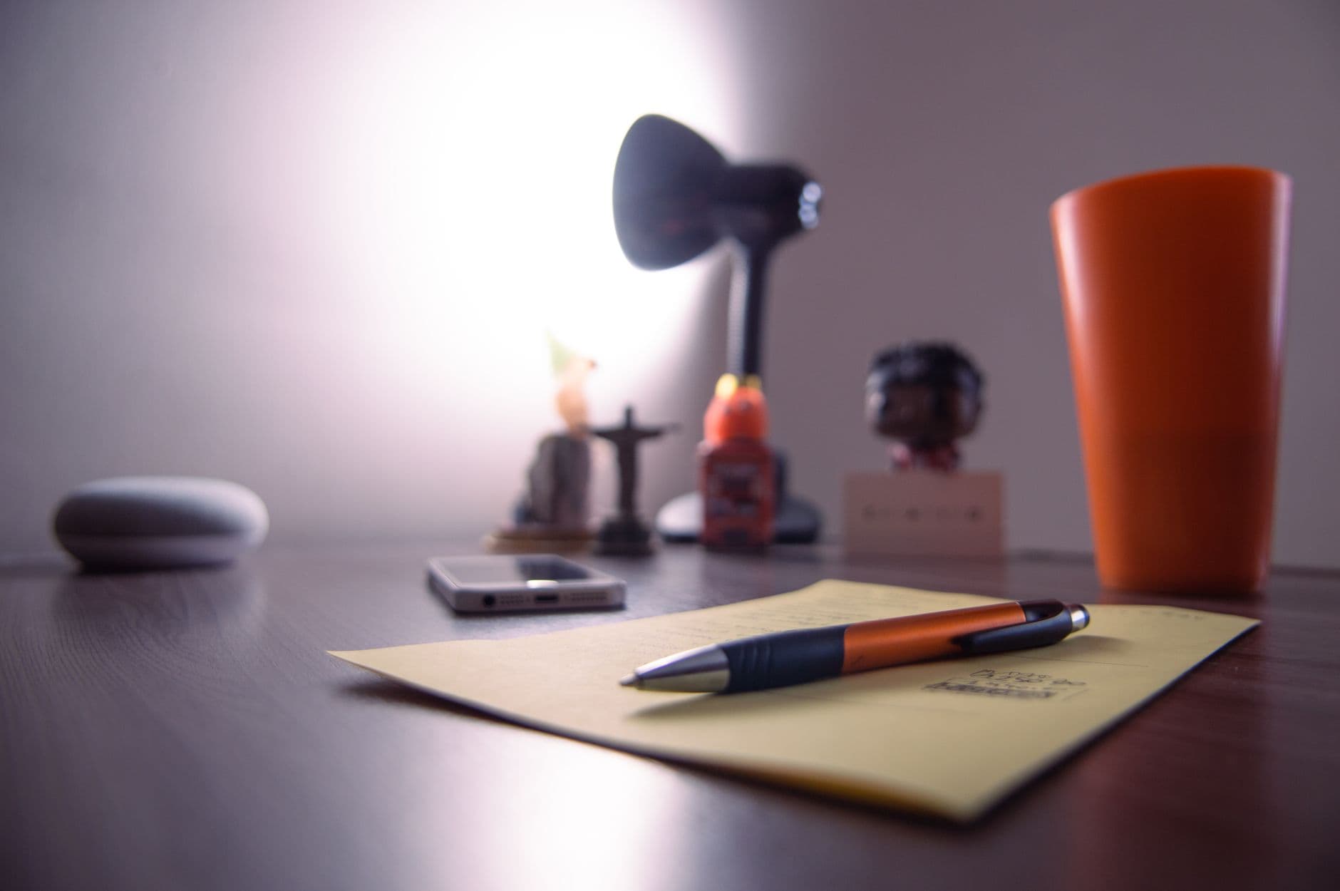 A paper logbook on a desk beside a pen