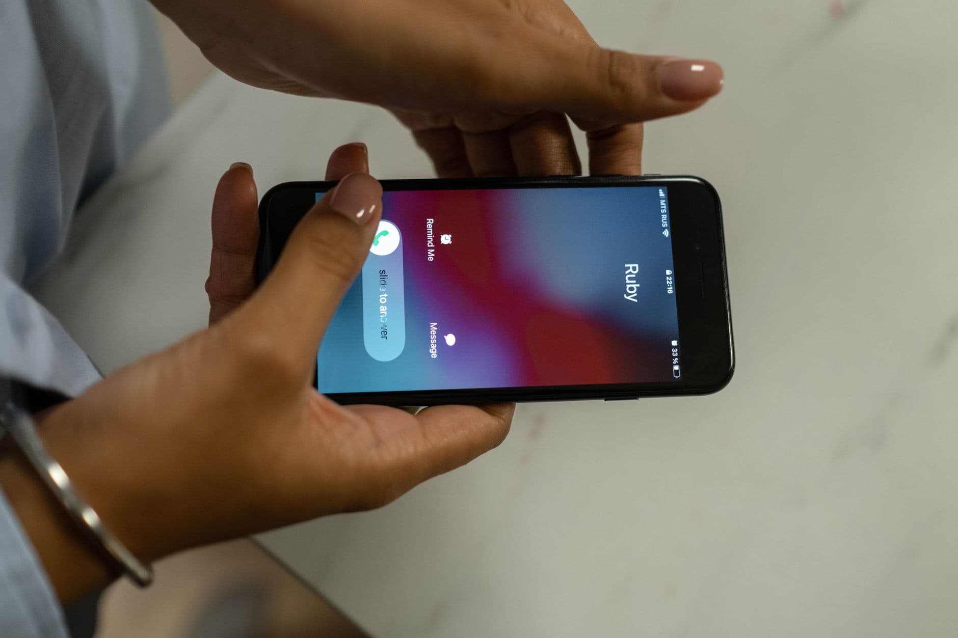A hand holding a phone showing an incoming call