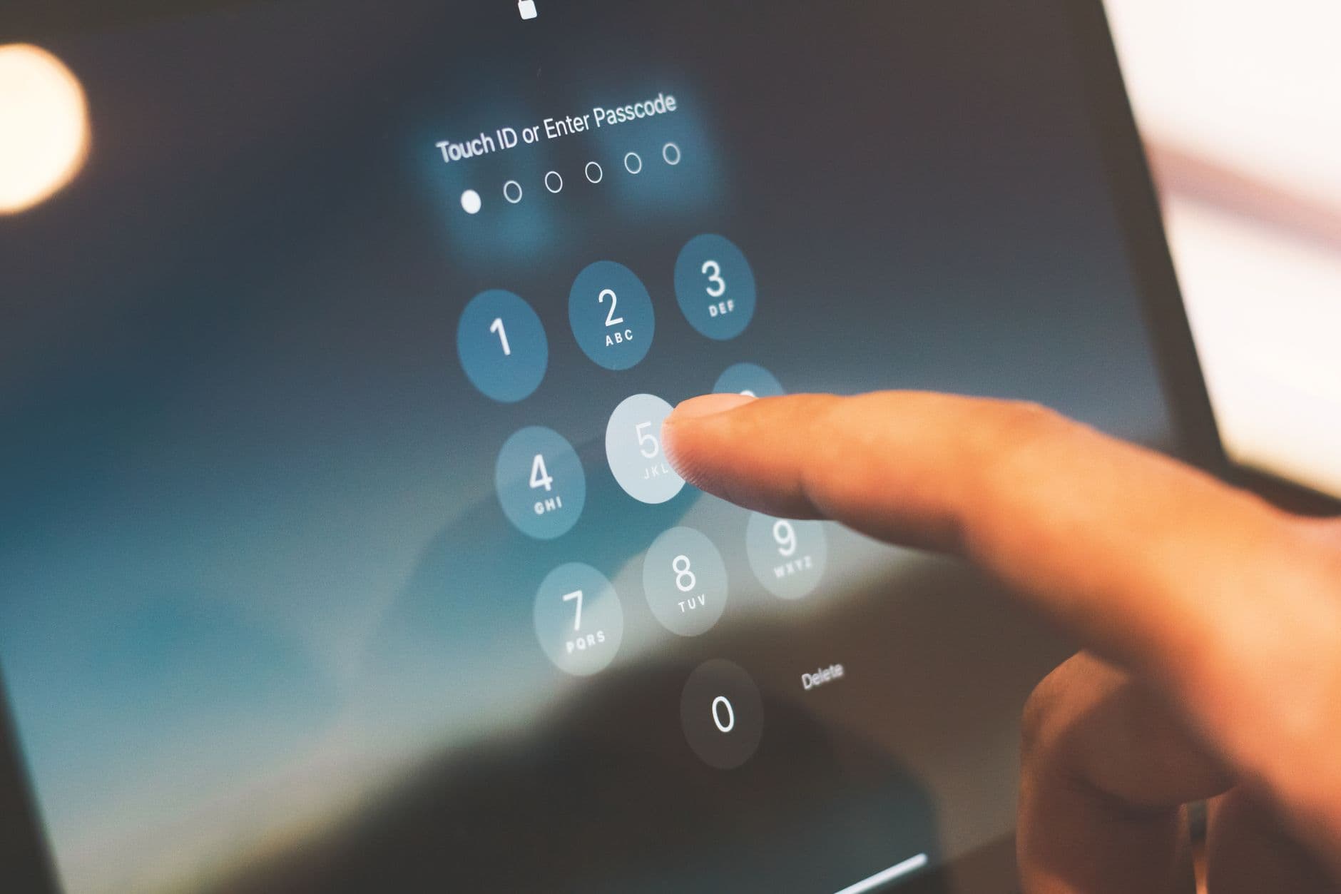 A hand entering a passcode on a smartphone