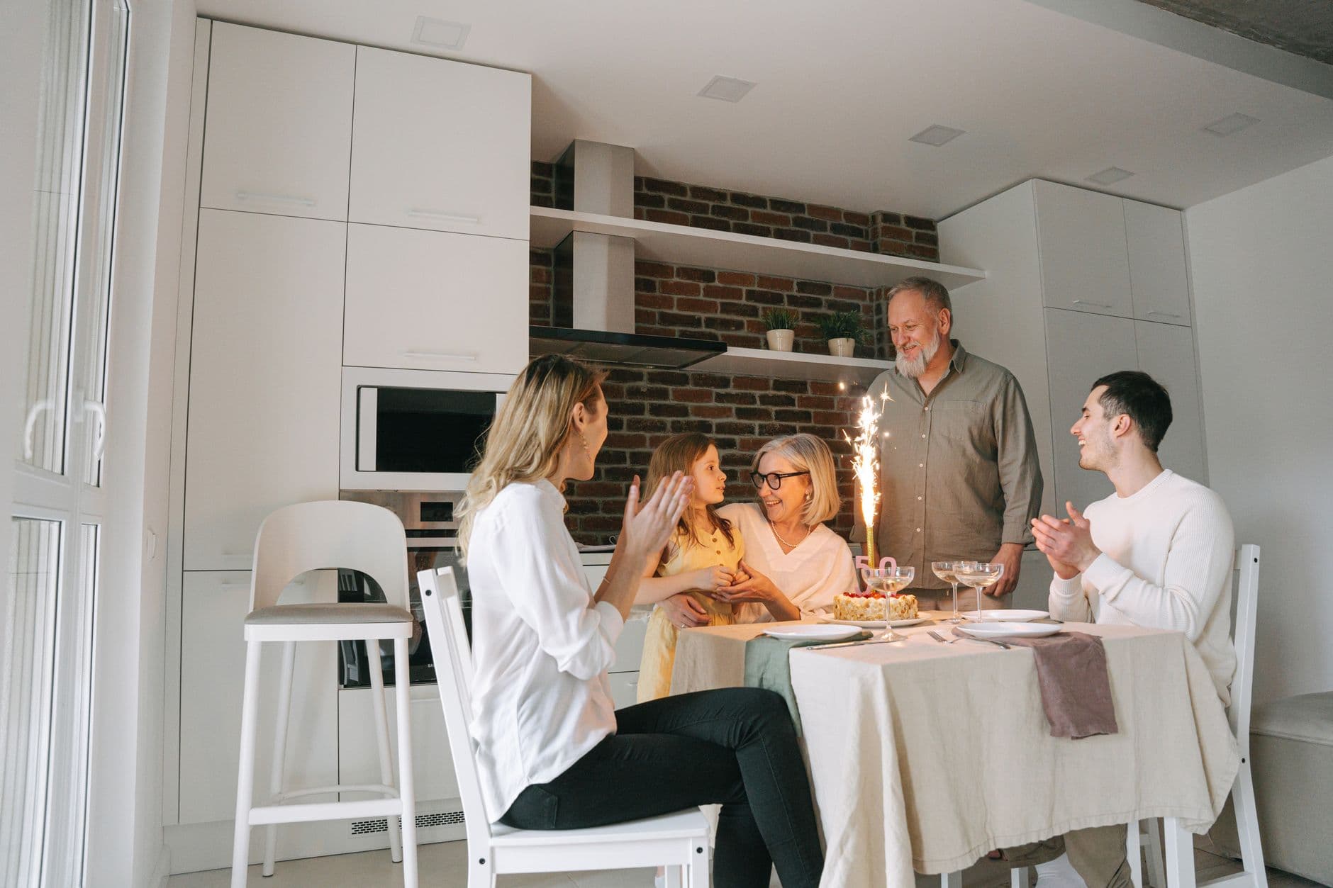 A family gathered around a birthday cake at the table