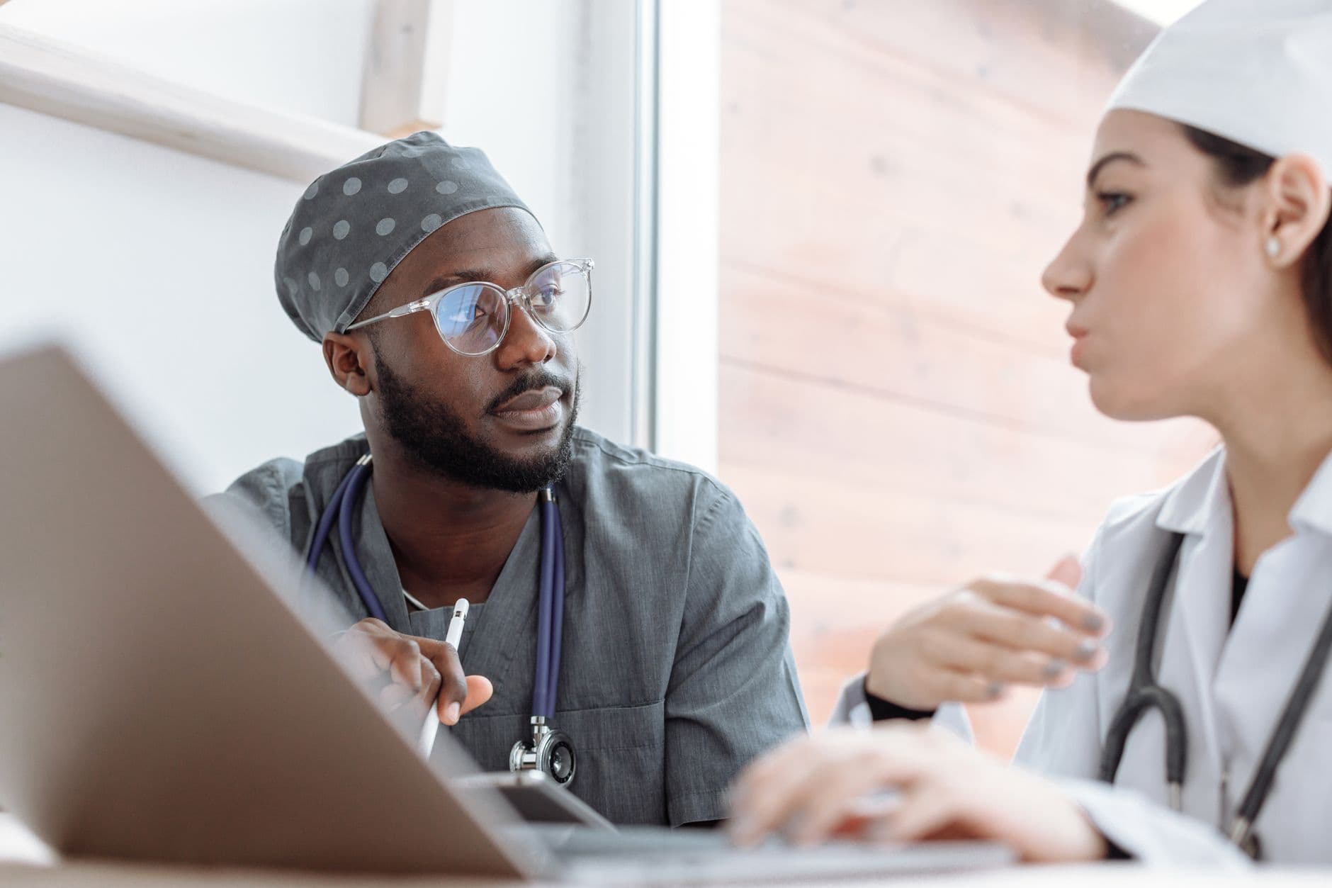 Two nurses talking at a hospital nurses' station