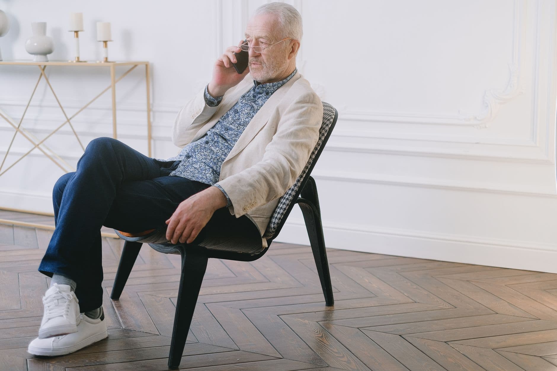 A senior man taking a phone call in an armchair