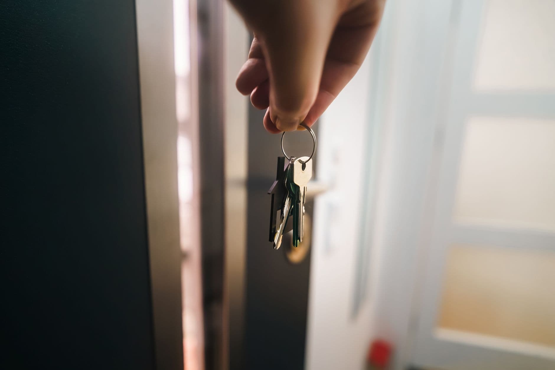 An estate agent holding keys at a front door