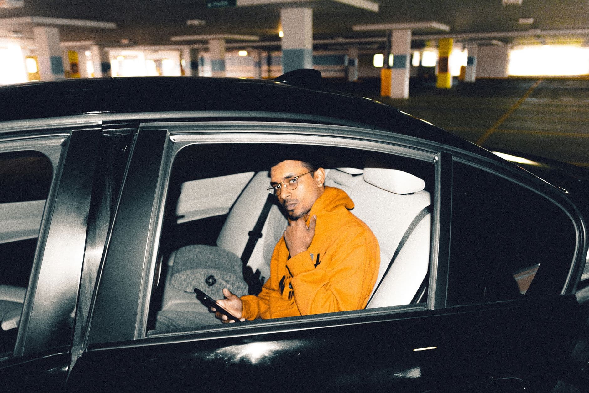 An estate agent using a phone while sitting in a parked car