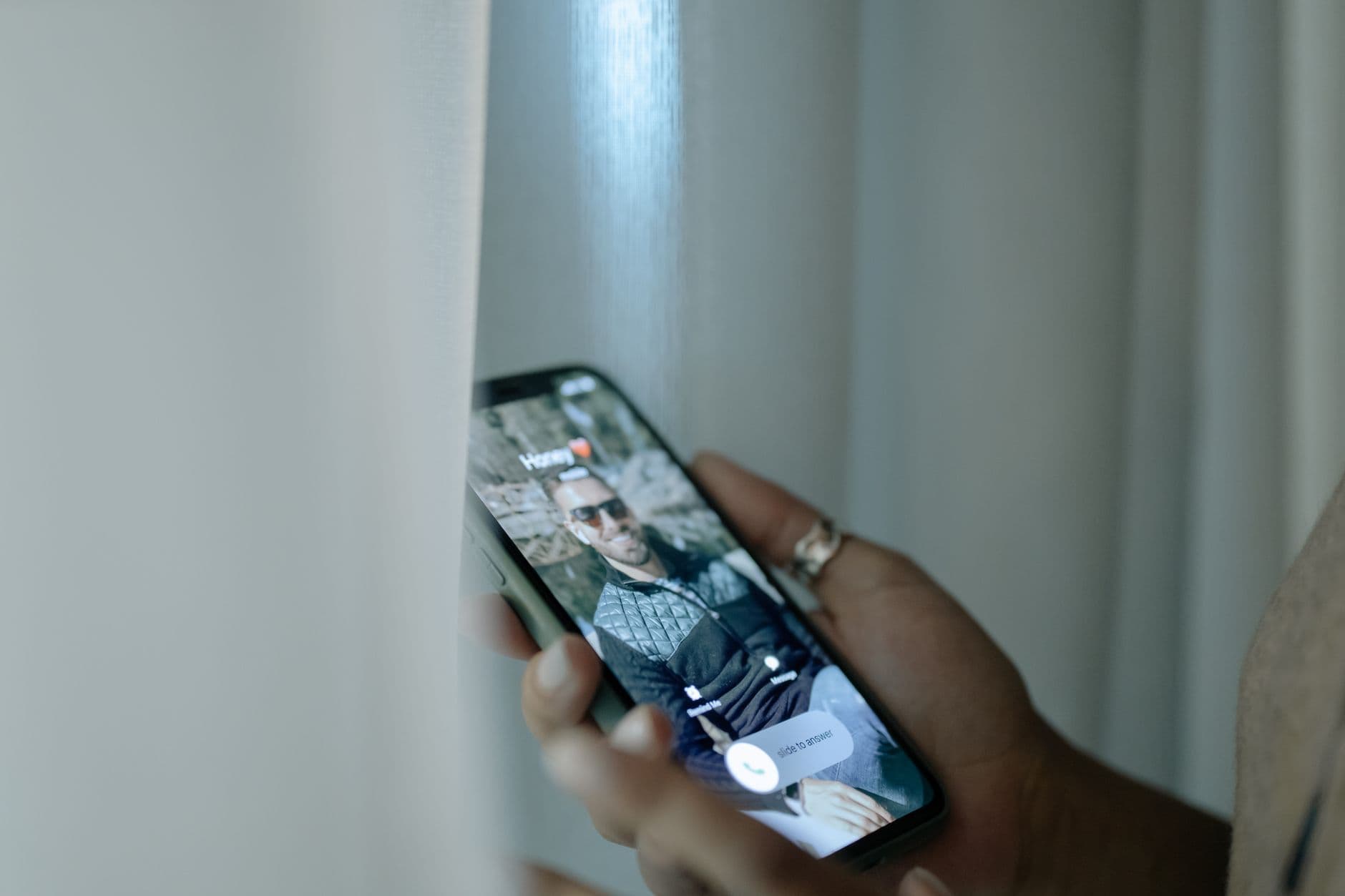 A hand holding a phone open on a call screen