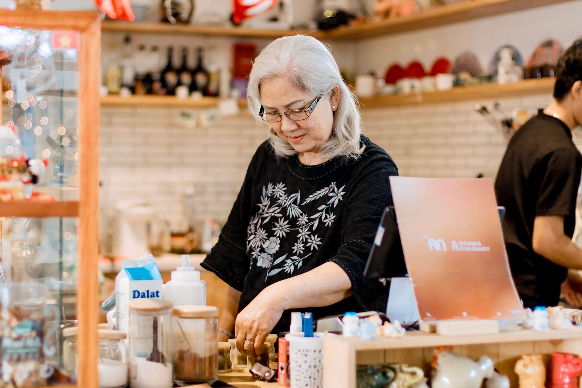 A shop owner going through paperwork behind the counter