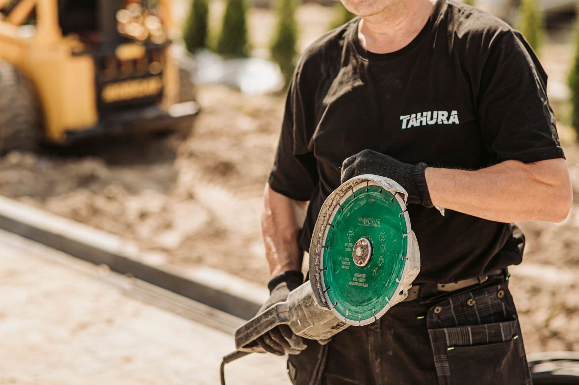 A tradesperson in work gloves standing by their van on site