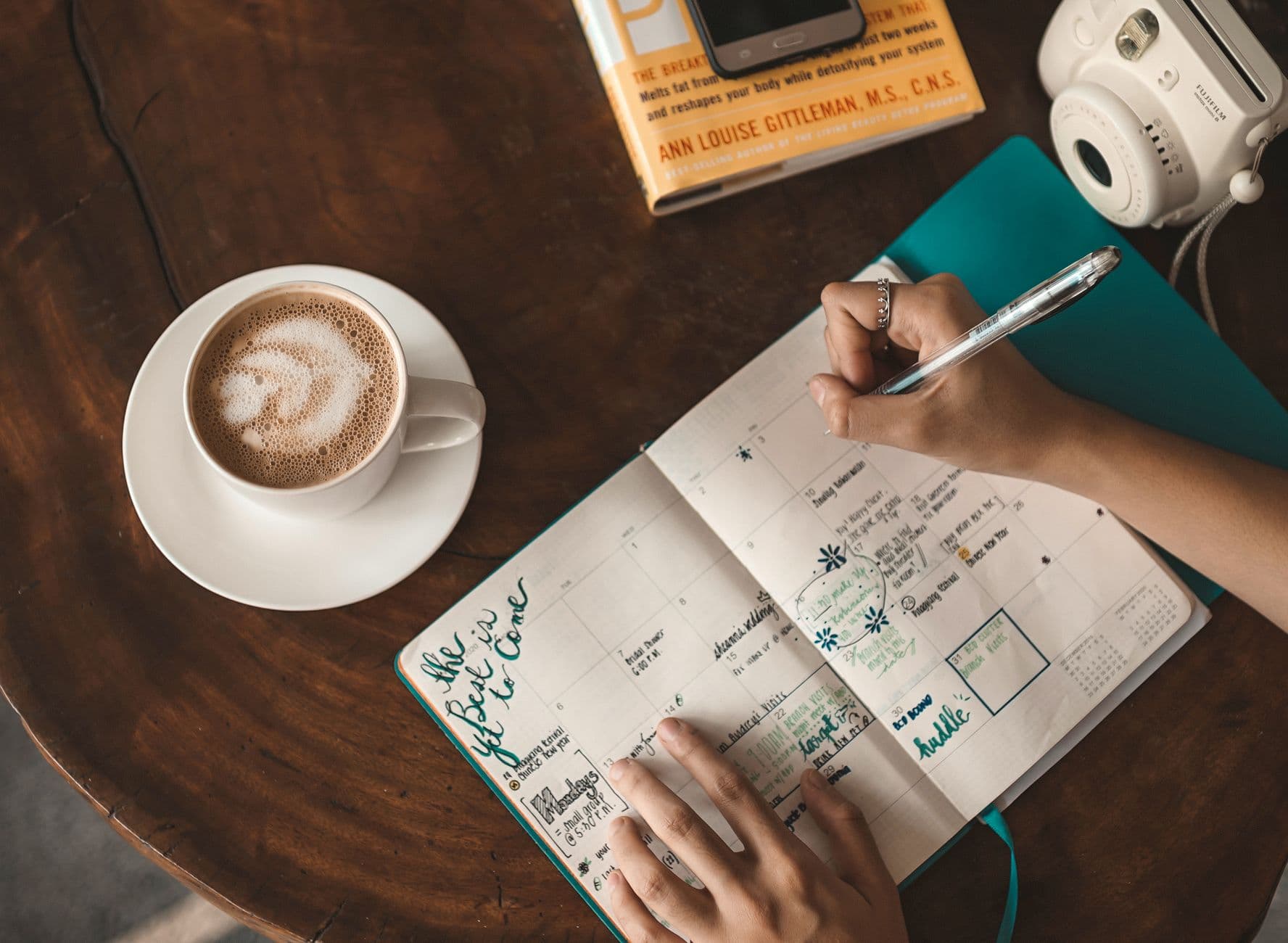 A woman writing in a weekly planner notebook
