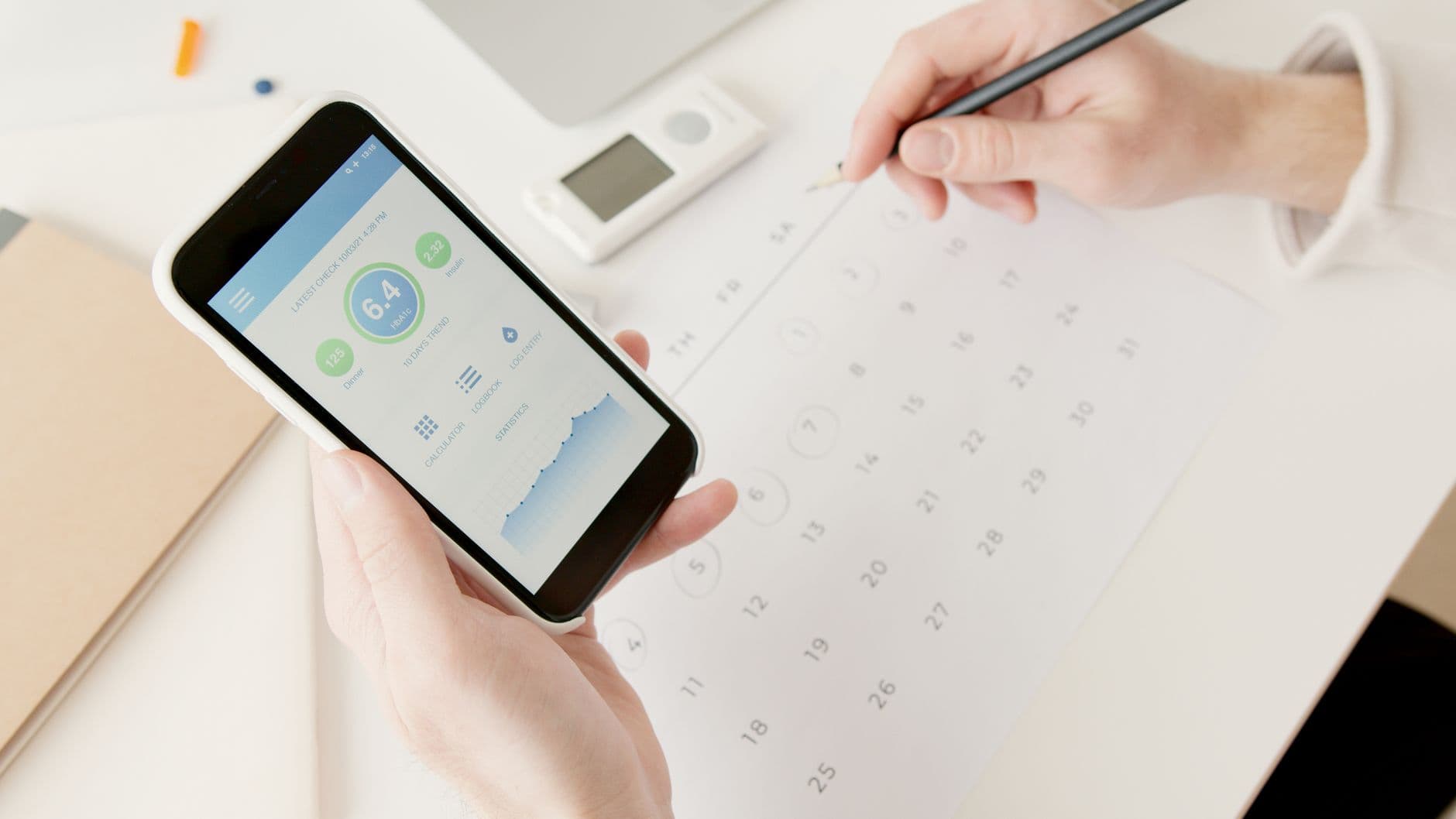 A pair of hands holding a smartphone open to a calendar app