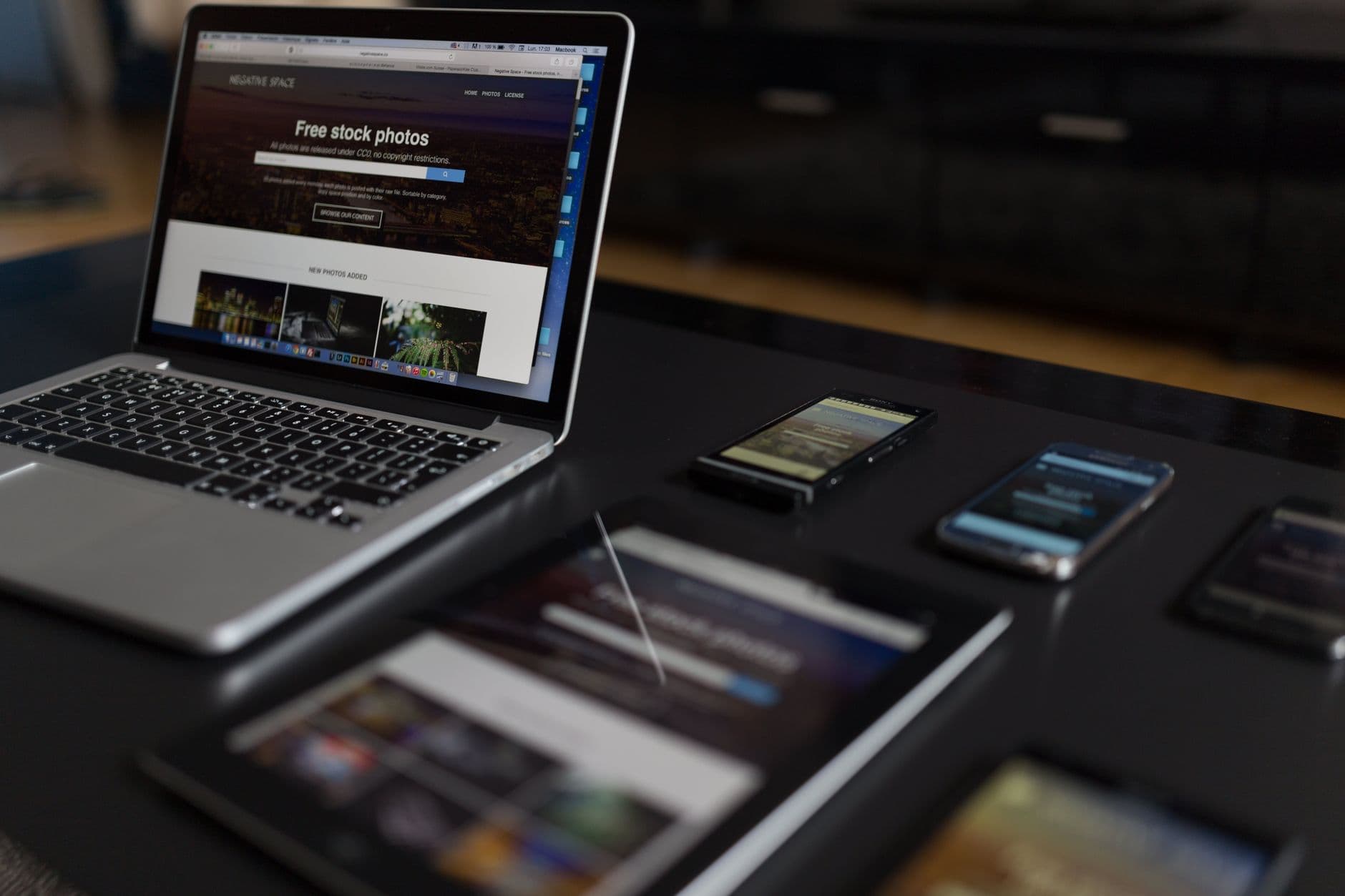 A laptop, a tablet and a phone side by side on a desk
