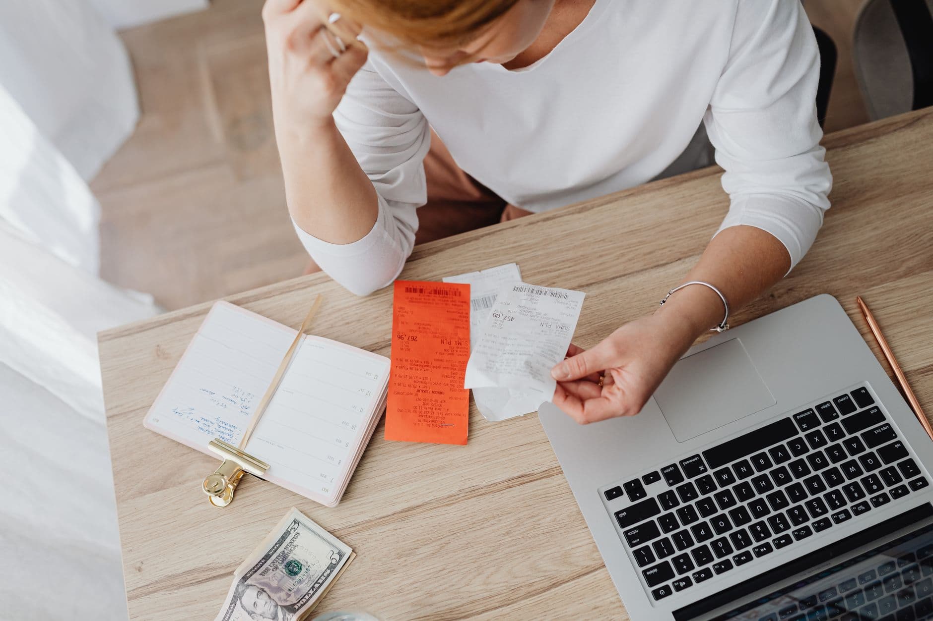 A woman reviewing a budget notebook at a table
